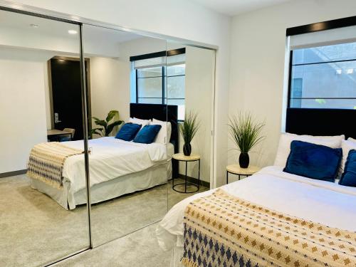Duas camas num quarto com espelhos em Beautiful Hollywood 1bd loft Plus Private Rooftop em Los Angeles