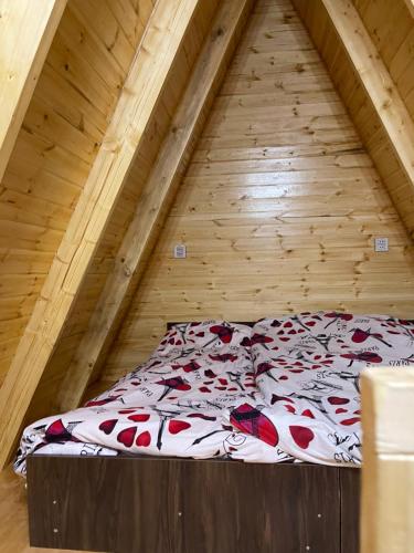 uma cama no meio de um sótão de madeira em A.frame.ev.naxcivan em Naquichevão