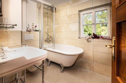 a bathroom with a tub and a sink and a window at Beautiful cosy House near Königsee in Schönau am Königssee