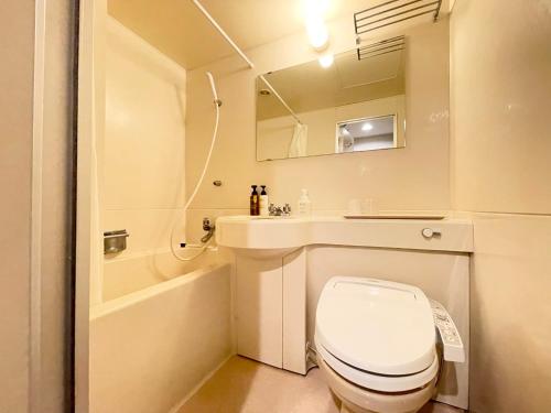 a bathroom with a toilet and a sink and a mirror at Smile Hotel Yonago in Yonago