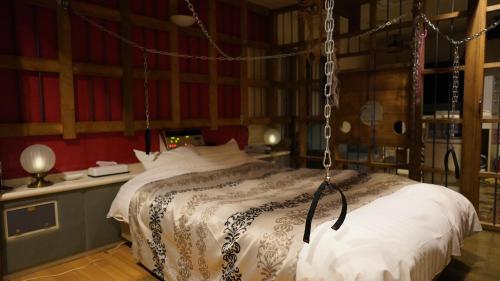 Un dormitorio con una cama colgante en una habitación en Hotel Vegas (Adult Only), en Sapporo