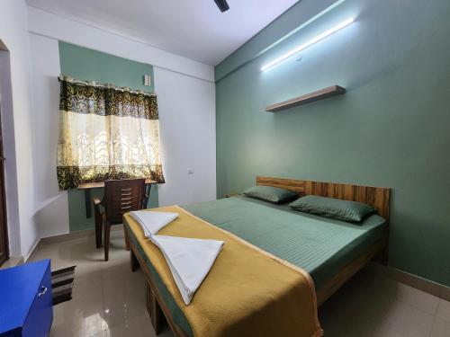 a bedroom with a bed and a desk and a window at SQUARSTAY in Bangalore