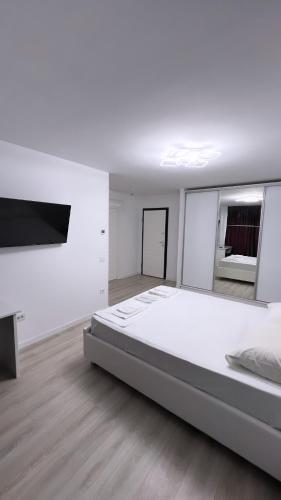 um quarto branco com uma cama grande e uma televisão de ecrã plano em Iași Poitier Towers Flat em Iaşi