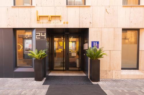 a building with two potted plants in front of it at Inn Boutique León in León