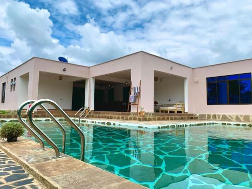 ein Pool vor einem Haus in der Unterkunft Backdoor Villa in Diani Beach