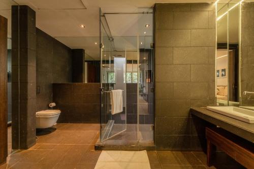 a bathroom with a glass shower and a toilet at Aster by Hireavilla - 3BR w Private pool in Parra in Parra