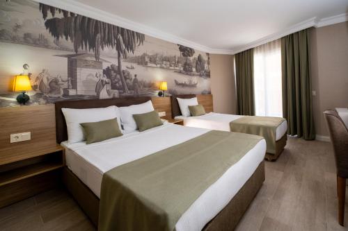 a hotel room with two beds and a couch at White Gold Hotel & Spa in Alanya