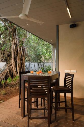 a wooden table and chairs with oranges on it at Aster by Hireavilla - 3BR w Private pool in Parra in Parra