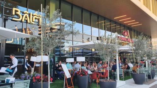 a group of people sitting at tables outside of a building at Crowne Plaza - Nice - Grand Arenas by IHG in Nice