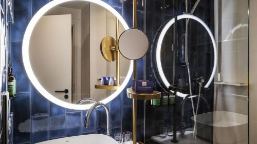 a bathroom with two mirrors and a sink at Crowne Plaza - Nice - Grand Arenas by IHG in Nice