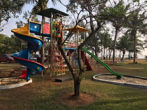 a playground with a slide in a park at Sea Breeze Beach Resort in Mahabalipuram