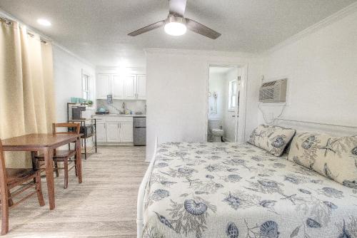 Cet appartement comprend une chambre avec un lit et une table ainsi qu'une cuisine. dans l'établissement Daytona Shores Inn and Suites, à Daytona Beach