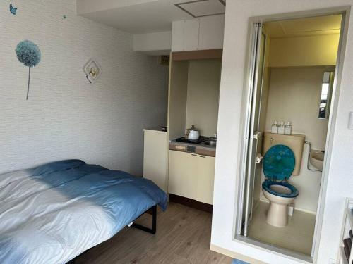 a small room with a bed and a toilet at North River 601 Peace Wing 6 in Kami-nagarekawachō