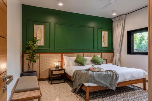 um quarto com uma parede verde e uma cama em City chic Luxury villa with Private pool available as 3bhk and 6Bhk em Old Goa