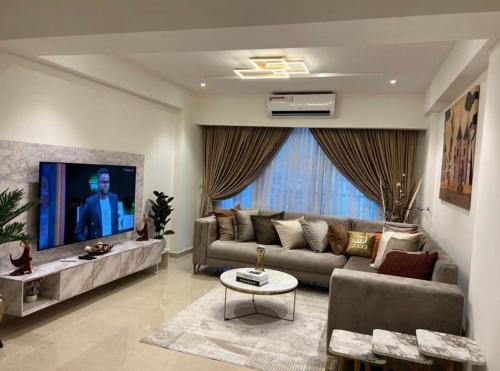 a living room with a couch and a tv at Executive One Bedroom Suite Space Available in Accra