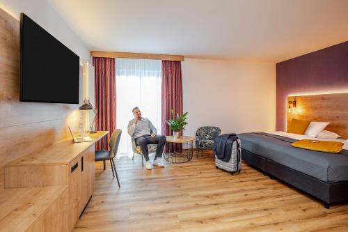 a woman is sitting in a hotel room at Mercure Hotel Bad Oeynhausen City in Bad Oeynhausen