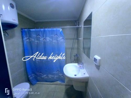 baño con cortina de ducha azul y lavamanos en Al dau heights, en Hurghada