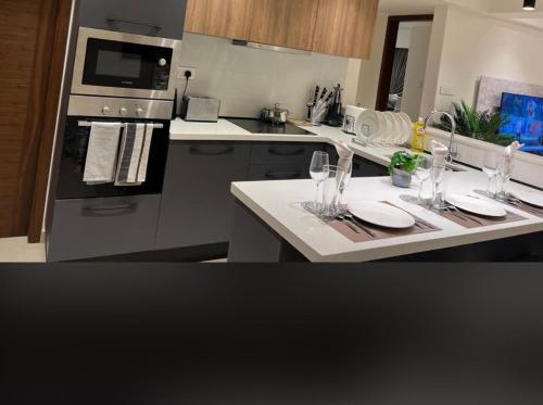 a kitchen with a table with wine glasses on it at Executive One Bedroom Suite Space Available in Accra