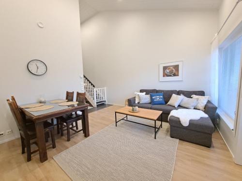 una sala de estar con un sofá y una mesa en Starvillas B302, en Kalajoki