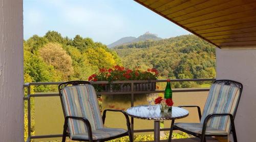 a table and chairs on a balcony with a view at Gasthaus Trifelsblick in Wernersberg