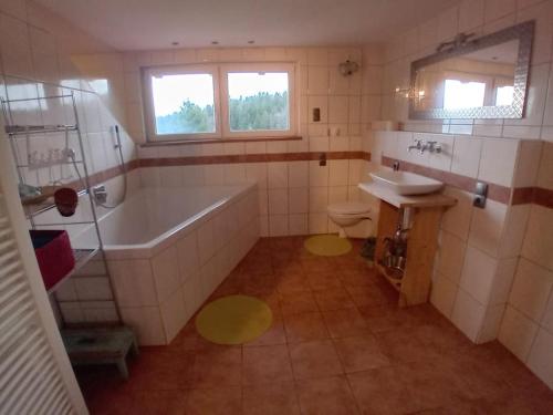a bathroom with a tub and a toilet and a sink at Musik und Natur - Balboo - Bayrischer Wald - Sauna - Pool - Grillen in Spiegelau