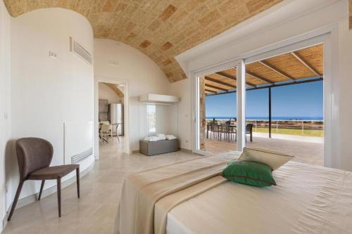 um quarto com uma cama grande e uma janela grande em Villa Don Cesare em Marina di Pescoluse