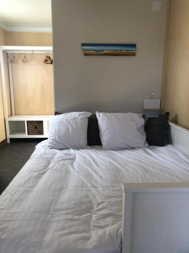 Elle comprend un grand lit avec des draps et des oreillers blancs. dans l'établissement Au Jardin d’AnneSo, à Limoges