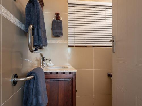 La salle de bains est pourvue d'un lavabo et d'une serviette bleue. dans l'établissement Siesta, à Ballito