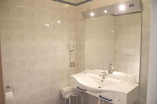 bagno bianco con lavandino e specchio di Hotel Casablanca a Lazise