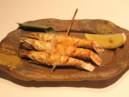 a plate of food with shrimp and a slice of lemon at APA Hotel Tottori Ekimae Minami in Tottori