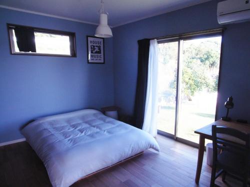 niebieska sypialnia z łóżkiem i oknem w obiekcie Goto - House - Vacation STAY 66191v w Gotō