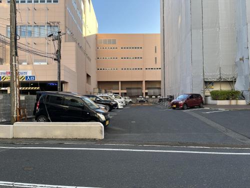a parking lot with cars parked in front of a building at APA Hotel Tottori Ekimae Minami in Tottori