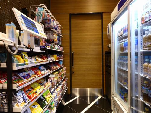 a store aisle of a store with a door and shelves of food at APA Hotel Asakusa Kaminarimon Minami in Tokyo