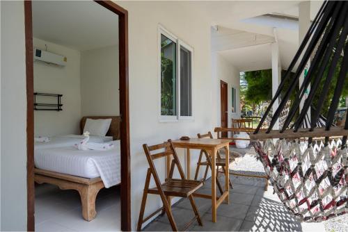 a room with a bed and a table and chairs at Isara Lanta Beach Resort in Ko Lanta
