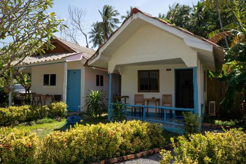 a small house with a porch in a garden at Isara Lanta Beach Resort in Ko Lanta