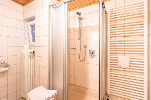 een badkamer met een douche met een glazen deur bij Haus Starlet in Oberstdorf