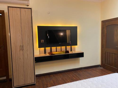 a bedroom with a flat screen tv on the wall at Orbit Residency F-7 in Islamabad