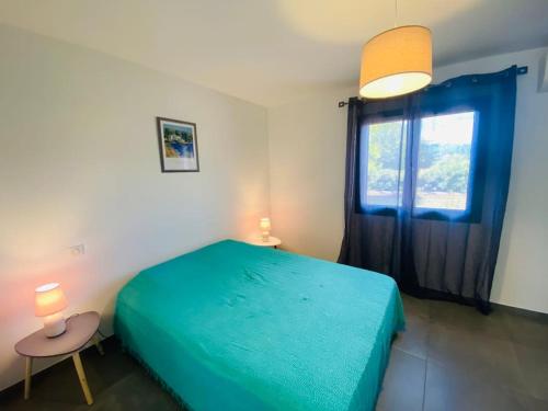a bedroom with a green bed and a window at "Villa Verde "au coeur de Ghisonaccia in Ghisonaccia