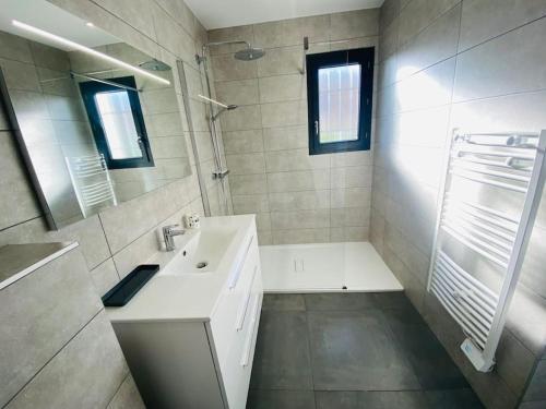 a white bathroom with a sink and a mirror at "Villa Verde "au coeur de Ghisonaccia in Ghisonaccia