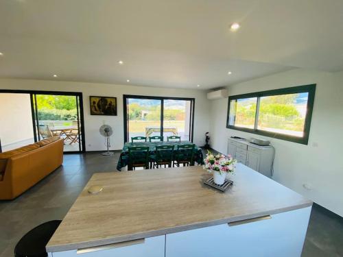 a kitchen and living room with a table and chairs at "Villa Verde "au coeur de Ghisonaccia in Ghisonaccia