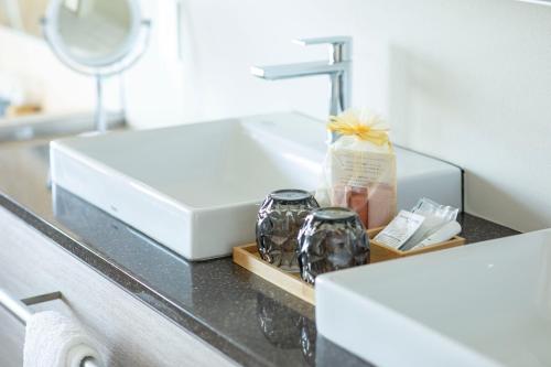 a bathroom counter with a sink and a mirror at Hotel Grand Bach Atami Crescendo in Atami
