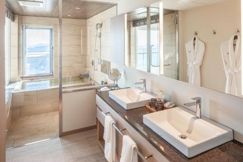 a bathroom with two sinks and a shower at Hotel Grand Bach Atami Crescendo in Atami