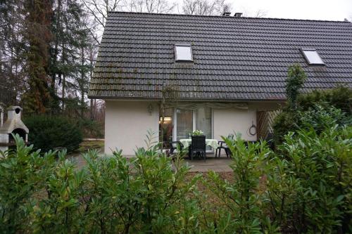 Casa blanca pequeña con mesa y sillas en Residenz am Ziest, en Lalendorf