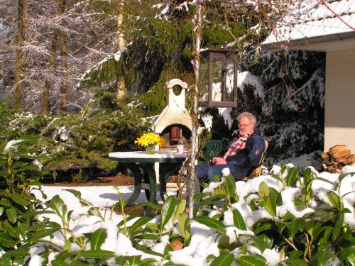 un hombre sentado en una mesa en la nieve en Residenz am Ziest, en Lalendorf