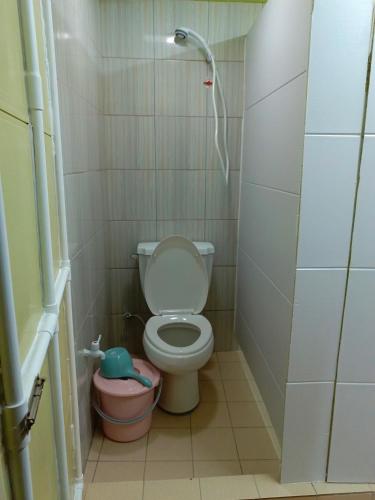 a small bathroom with a toilet and a bucket at Maburo sea breeze suites in Majuro