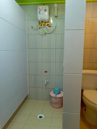 a small bathroom with a toilet and a shower at Maburo sea breeze suites in Majuro