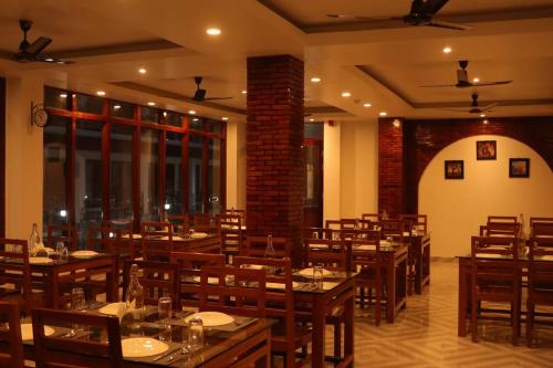 a dining room with wooden tables and chairs at Hotel Havelock Gateway in Havelock Island