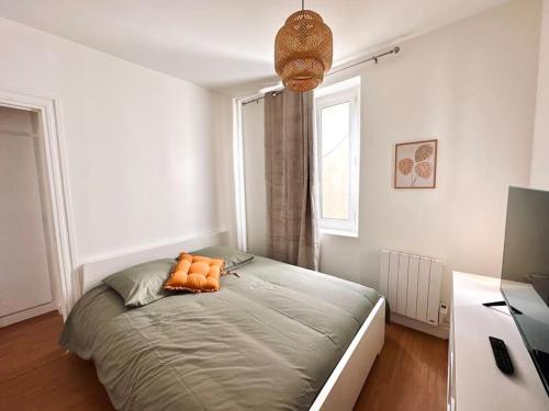 - une chambre dotée d'un lit avec deux oreillers orange dans l'établissement Cosy Saint-Denis 2/4 personnes, à Saint-Denis