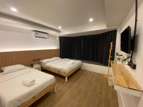 a hotel room with two beds and a flat screen tv at THE BEST ONE CHIANG MAI in Chiang Mai