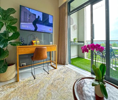 uma sala de estar com uma televisão e uma mesa com uma cadeira em Menlyn Maine Residences - Central Park with king sized bed em Pretoria